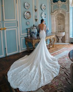 a woman in a wedding dress is standing near a table with plates and vases on it