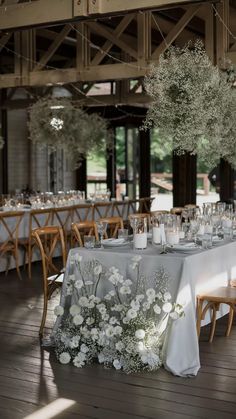 the table is set with white flowers and candles for an elegant wedding reception or special event