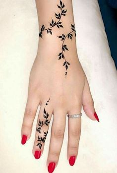 a woman's hand with black leaves on it