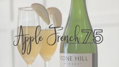 an apple french 75 wine bottle next to two champagne glasses with the words apple french 75