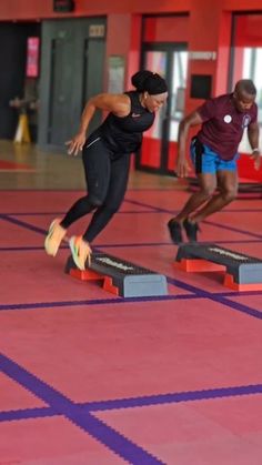 two men are doing tricks on their skateboards in a gym with purple and red tiles