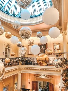 an indoor christmas tree in the middle of a building with lots of ornaments hanging from it's ceiling