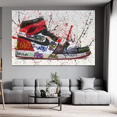 a living room with a white couch and a painting on the wall above it that has red paint splatters all over