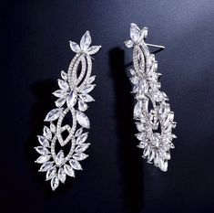 A delightfully unique pair of wedding earrings for the unconventional bride! The flawlessly faceted cubic zirconia stones capture the light in a dazzling array of sparkles, while the delicate links add fluidity and motion. The earrings are rhodium plated for a bright finish which enhances the intricate detailing and conveys a modern take on old elegance. Length: 2.5" (approx. 6.3cm); Width: 0.8" (approx. 2.2cm); Weight: 17g. Hypoallergenic - lead, nickel and cadmium free. This exquisite design w Intricate Cubic Zirconia Earrings For Wedding, Wedding Chandelier Earrings With Intricate Cubic Zirconia Design, Cubic Zirconia Chandelier Drop Earrings With Intricate Design, Intricate Cubic Zirconia Dangle Bridal Earrings, Silver Bridal Earrings With Rhinestones, Cubic Zirconia, Cubic Zirconia Bridal Earrings, Unconventional Bride, Silver Wedding Jewelry, Exquisite Design