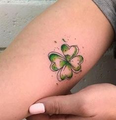 a woman's arm with a clover tattoo on it