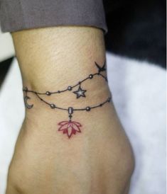 a woman's foot with a tattoo on the ankle and stars around her ankles