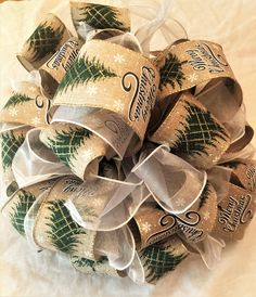 a close up of a christmas wreath on a white sheet with ribbon around the center