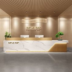 an empty reception area with marble counter tops and gold accents on the walls, along with potted plants