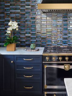 a stove top oven sitting inside of a kitchen next to a wall covered in magnets