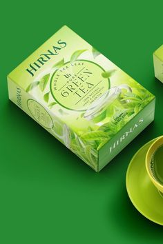 a green tea cup and saucer next to a box of himala's