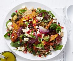 a white plate topped with salad next to a glass of orange juice