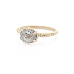 a gold ring with an oval gray diamond