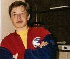 a young man wearing a red and blue jacket with his arms crossed in front of him