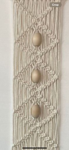 a white wall hanging with three balls on it