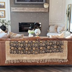 a living room filled with furniture and a large painting on the wall above it's fireplace