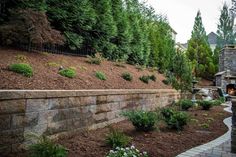 a stone retaining wall with landscaping around it