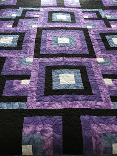 a purple and black quilt with squares on it