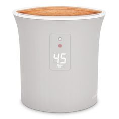 an electronic clock is displayed on the side of a white container with wood trimmings