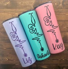 three personalized water bottles are lined up on a wooden surface with the names of each individual