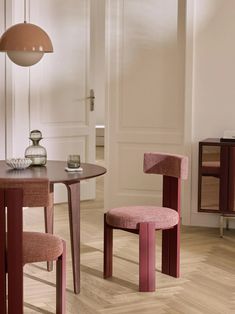 two pink chairs sitting next to each other on top of a hard wood floored floor