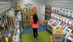 a woman is walking through a store aisle with boxes and packages on the shelves behind her