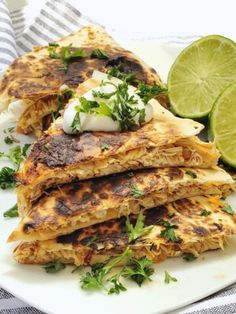 some food on a white plate with lime wedges