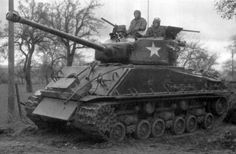 two men sitting on top of an army tank