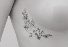 a woman's breast with flowers and leaves tattooed on the back of her stomach