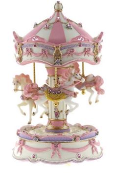 a pink and white carousel with horses on it's sides, in front of a white background