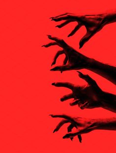 several hands reaching up in the air against a red background