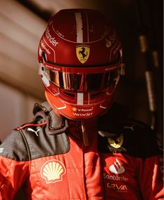 a man wearing a red racing suit and helmet