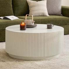 a white coffee table with a candle on it