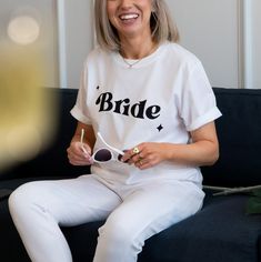 "If you're just about to get married or the planning the hen party, these t-shirts are perfect! Text reads: Bride in black retro print. For neon pink - click here: https://www.etsy.com/uk/listing/1518543084/retro-bride-hen-party-t-shirt-neon-pink?ref=listings_manager_grid There is also the option to add \"We bring the party\" to the back of the t-shirt! Back print features cocktail glass and disco ball. Matching bridal party tees available on our store front to purchase for the hen party or the White Bridal T-shirt With Short Sleeves, Black Crew Neck T-shirt For Bachelorette Party, White Short Sleeve Bride T-shirt, Bride's White Short Sleeve T-shirt, Hen Party Short Sleeve T-shirt With Letter Print, Black Short Sleeve T-shirt For Bachelorette Party, Short Sleeve T-shirt For Hen Party With Letter Print, Bride In Black, Bachelorette Tees