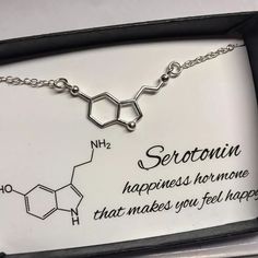 a necklace with the words seroturnn on it in a black and white box