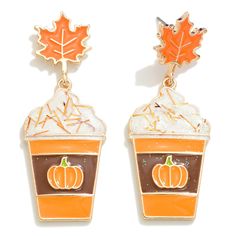 two orange cupcakes with frosting and an orange leaf on top are hanging from earrings