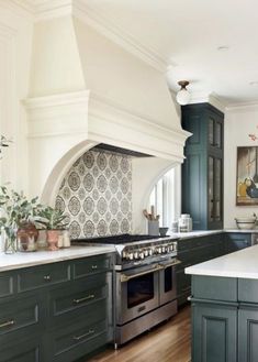 a large kitchen with green cabinets and white counter tops is pictured in this image, there are potted plants on the stove