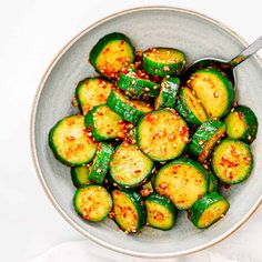 a bowl filled with cooked zucchini on top of a white table