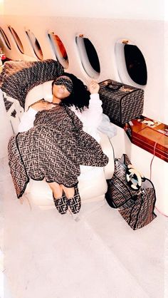 a woman laying on top of a bed next to luggage