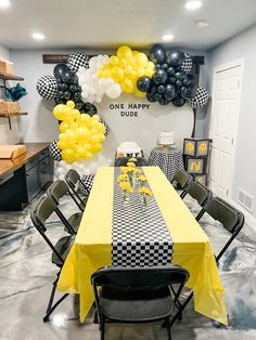 a table with yellow and black balloons on it