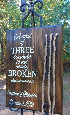 a wooden sign with rope hanging from it's sides