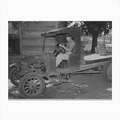 an old truck with a man sitting in the driver's seat