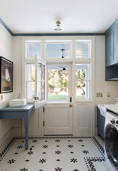 a washer and dryer in a small room with tile flooring on the floor