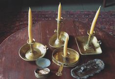 three candles are sitting on a table with other items around it, including one candle holder