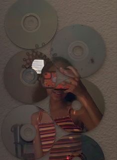 a woman taking a selfie in front of several cds