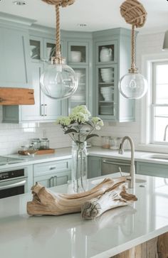 a kitchen with blue cabinets and white counter tops, an island in the middle has flowers on it