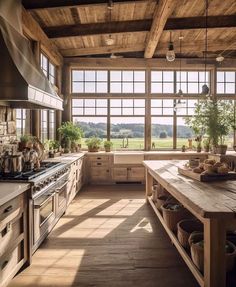 a large kitchen with lots of windows and wooden furniture in the center, along with potted plants on the counter