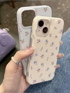 a woman is holding up her phone case with flowers on the front and back sides