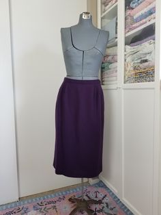 "Perfect wardrobe building skirt! This is made with a wool (crepe probably) mid weight fabric and is a lovely eggplant like color. Has side inseam pockets and is fully lined in acetate! There is a small kick pleat. Zips at back. Condition: Excellent condition. General, minor signs of wear. Label says 12 Measurements Waist: 29\", snug 30\" Hip: 40\" Length: 29\"" Purple Pencil Skirt For Work, Fitted Purple Pencil Skirt, Purple Fitted Pencil Skirt, Purple Fitted Skirt For Work, Fitted Purple Skirt For Work, Seersucker Skirt, Wardrobe Building, Dress And Jacket Set, Wool Crepe