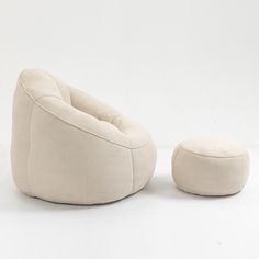 a white chair and footstool sitting next to each other on a white surface