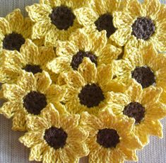 crocheted sunflowers are arranged on a table